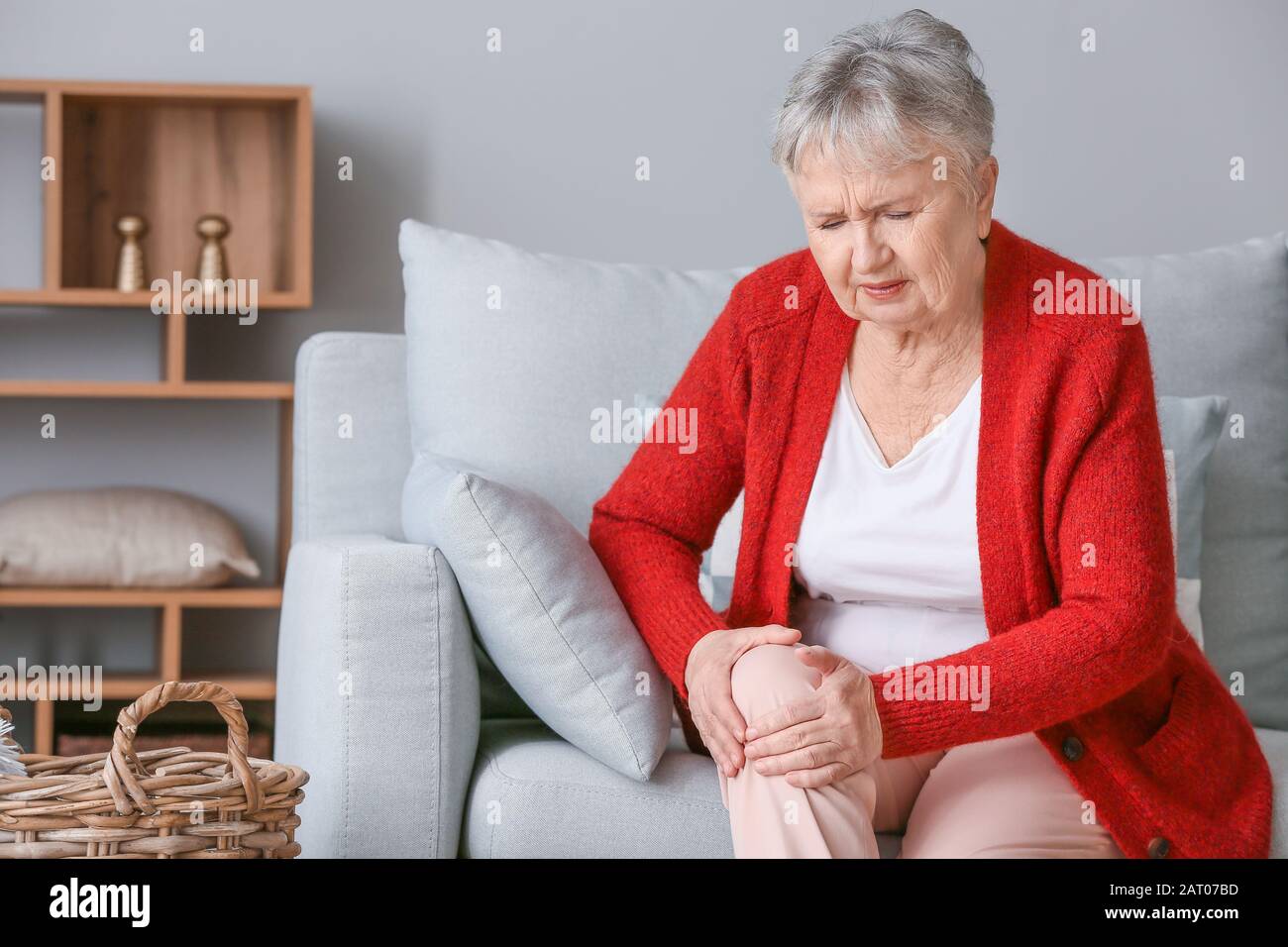 Femme senior souffrant de douleur au genou à la maison Banque D'Images