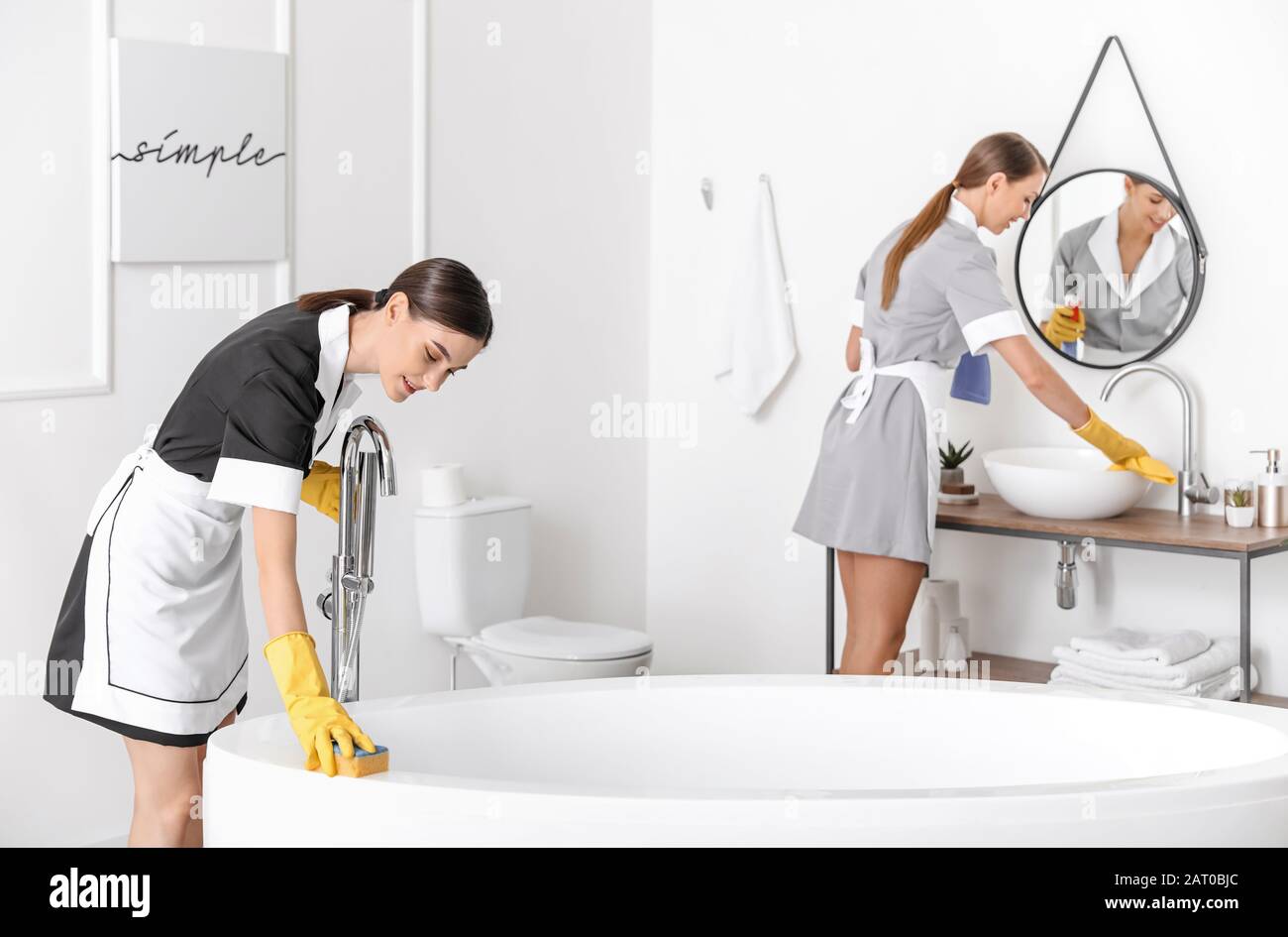 Belle chambre chambermaids nettoyage de la salle de bains de l'hôtel Banque D'Images