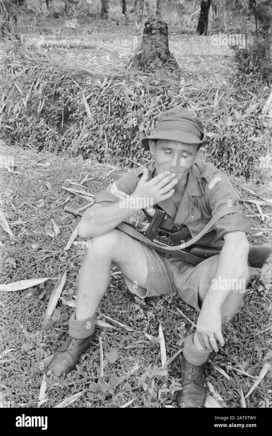 Poerwokerto, Tegal et Banjoemas un caporal fume une cigarette pendant une pause. Sur ses genoux se trouve une annotation Tommygun: Le caporal porte l'emblème du manchon Friesland (1-9 R.I.). Au cours de cette période, des parties de ce régiment ont été stationnées à Bukatedja, Bolotsari et Sukaredja. Et l'action dont on a fait l'éloge a été Tjimahi, Bandoeng, Poerbalingga et al Date: 22 Décembre 1947 Lieu: Banuymas, Indonésie, Java, Hollandais East Indies, Purwokerto, Tegal Banque D'Images