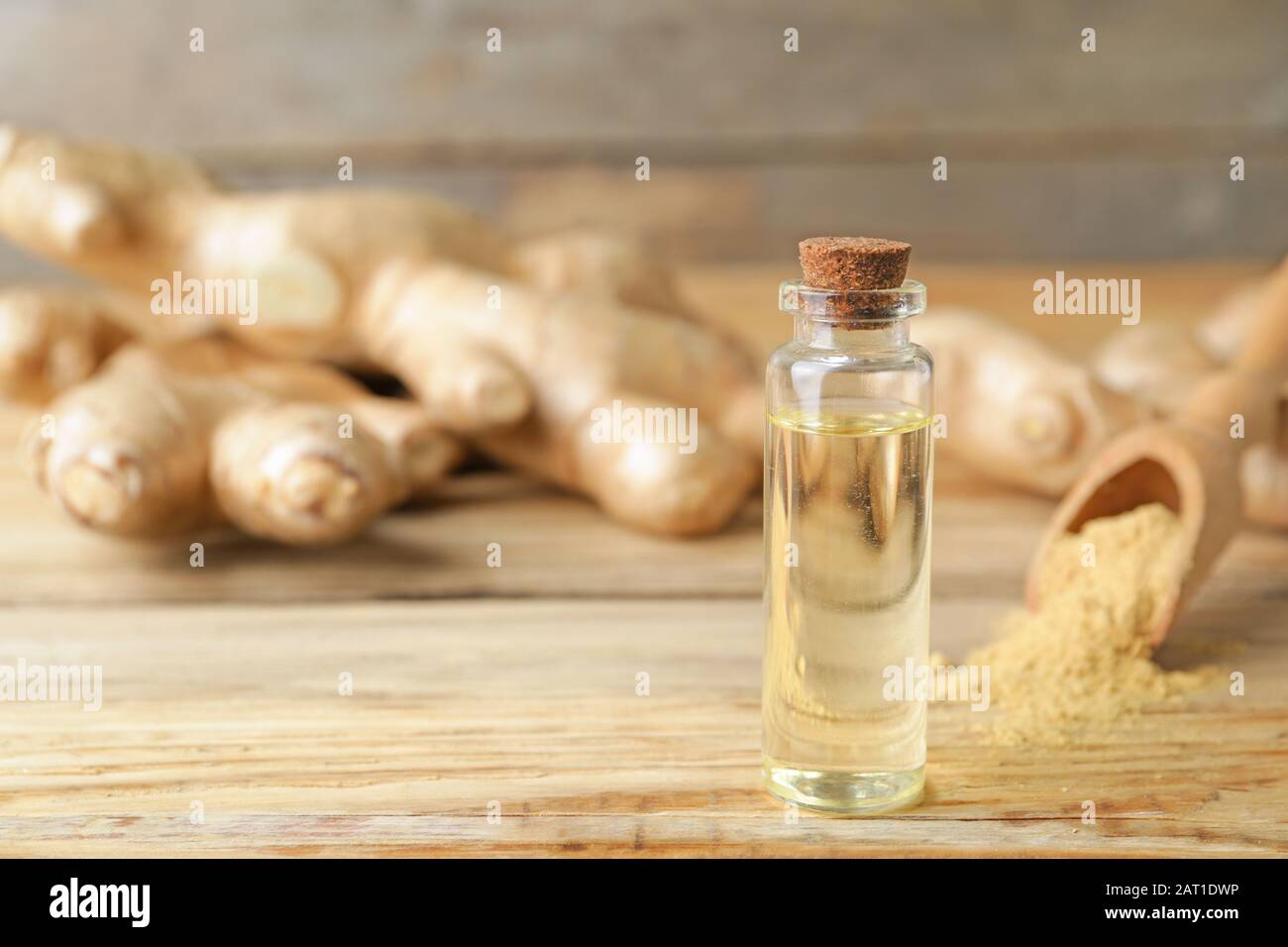 Bouteille d'huile essentielle de gingembre sur table en bois Banque D'Images