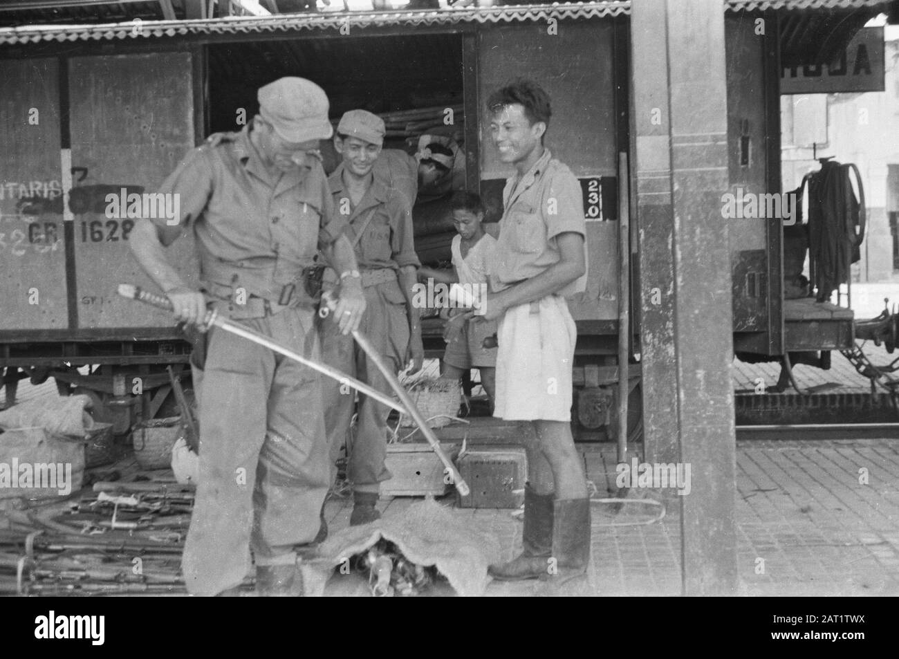La station intermédiaire Kroja lors de l'évacuation des troupes de l'INT Evacuation des troupes républicaines du territoire occupé par l'armée néerlandaise. Armement des soldats de l'INT de la première Division de la Rép. Venant de la région au sud de Bandjar. Les troupes de l'INT ont été transportées en train jusqu'à Gombong et de là avec des camions de l'armée jusqu'à la zone de la Rép. Le transport des armes qui leur appartiennent était sous surveillance mixte néerlandaise et républicaine. Annotation: Un officier néerlandais avec une épée d'officier japonais Date: Février 1948 lieu: Indonésie, Java, Kroja, Antilles néerlandaises de l'est Banque D'Images