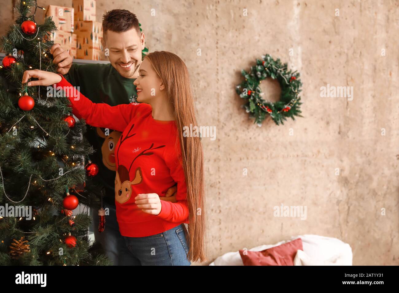 Heureux couple decorating Christmas Tree at home Banque D'Images