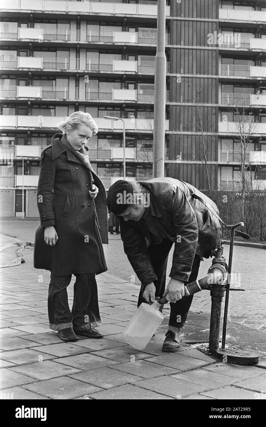 Flatdwellers à Ridderkerk obtenir de l'eau de la pompe, parce que deux personnes sont entrées dans le coma en raison de cause inconnue Date: 11 Janvier 1977 lieu: Ridderkerk mots clés: Coma, résidents, appartements Banque D'Images