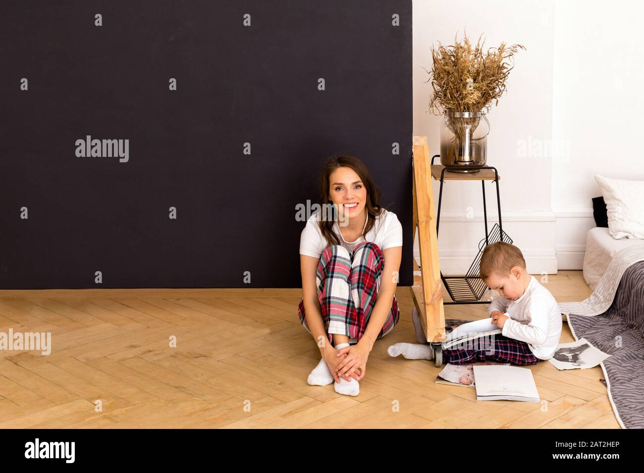 Son dessin sur papier assis sur le sol avec une mère heureuse Banque D'Images