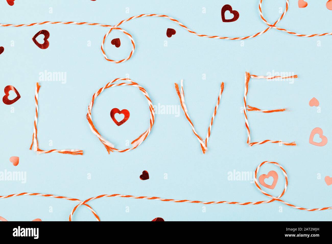 La composition de la Saint Valentin avec mot Amour et confetti sur fond bleu. Plat, vue de dessus. Élément design pour cartes de vœux, vente Banque D'Images La composition de la Saint Valentin avec mot Amour et confetti sur fond bleu. Plat, vue de dessus. Élément design pour cartes de vœux, vente Banque D'Images