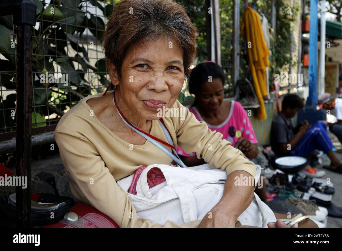 Antipolo City, Philippines - 29 janvier 2020: Une femme philippine adulte assise sur un trottoir pour la caméra. Banque D'Images