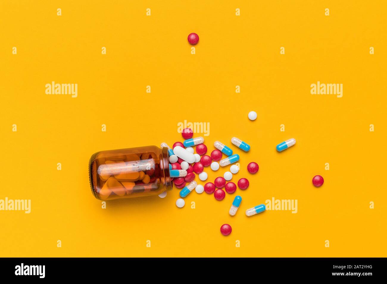 Pilules et capsules enrobées de film déversées de la bouteille avec espace de copie, vue de dessus Banque D'Images