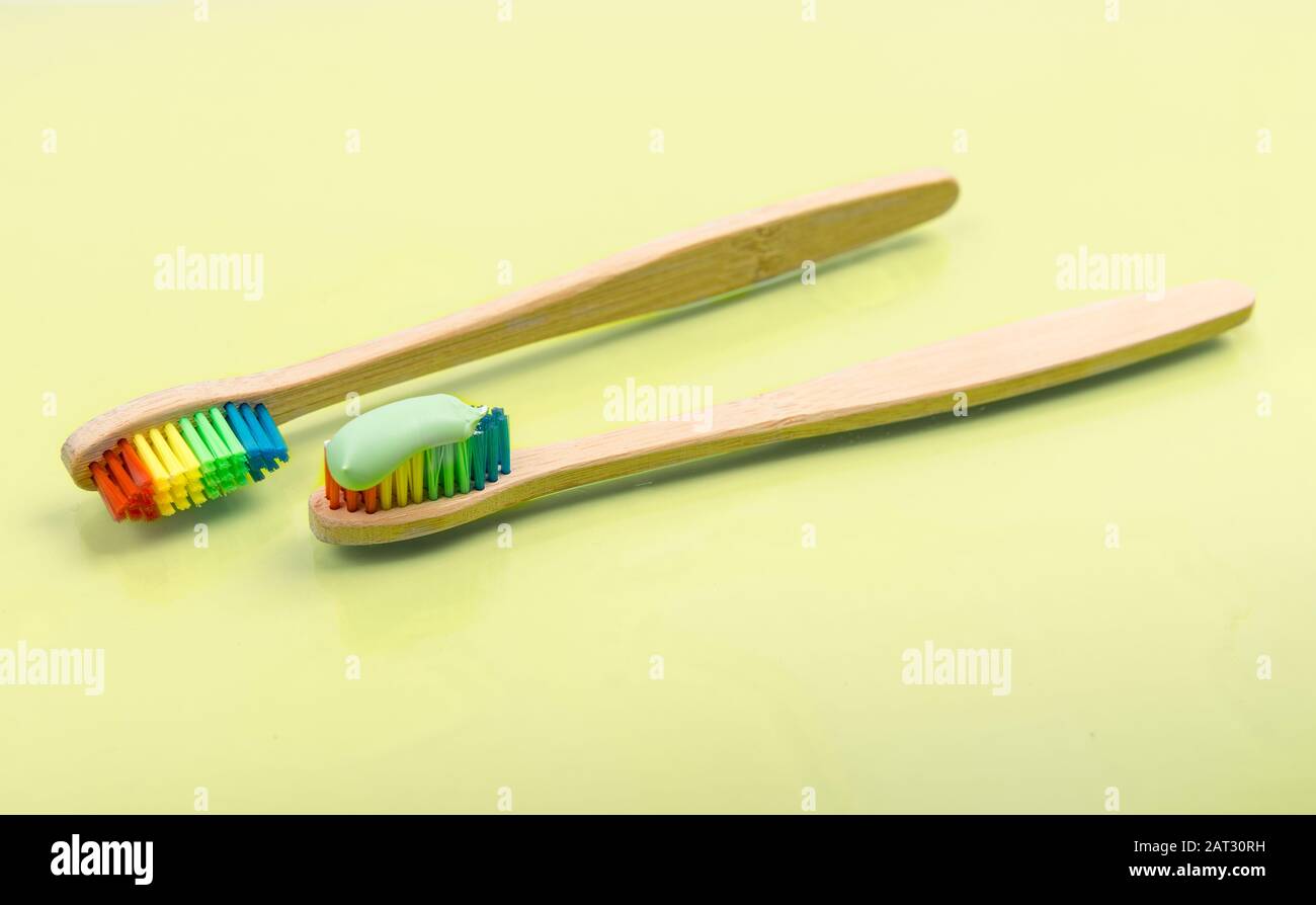 Brosse à dents en bambou avec dentifrice écologique sur fond pastel. Paire de brosses à dents en bois multicolores Banque D'Images