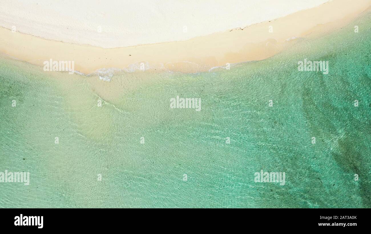 Douce vague bleue sur une plage de sable propre, vue sur le dessus. Lagon transparent et sable blanc. Concept de vacances d'été et de voyage. Banque D'Images