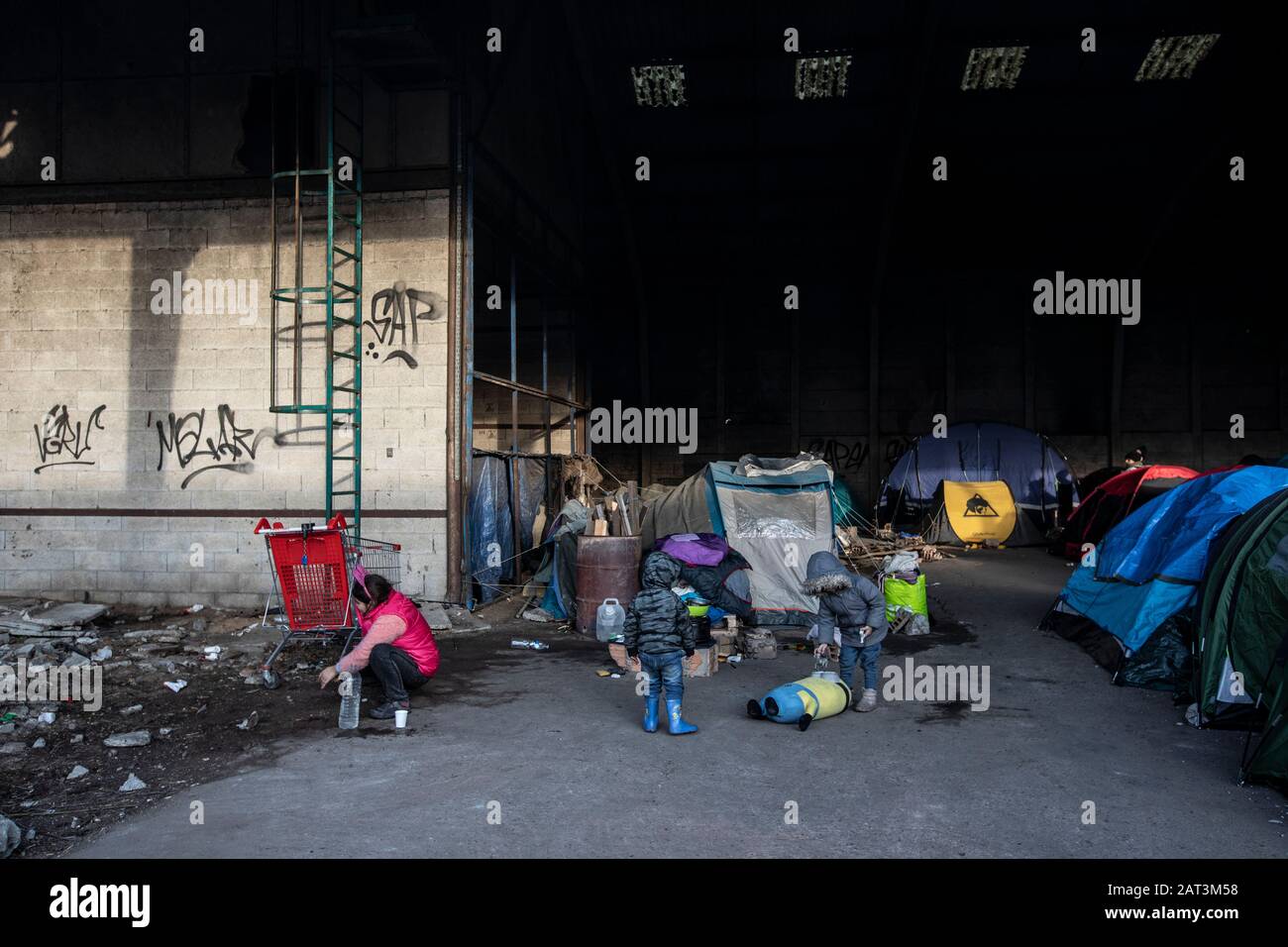 Les immigrants kurdes irakiens qui prennent refuge dans des tentes parmi les décombres d'un entrepôt abandonnée à la périphérie de Dunkerque alors qu'ils essaient de rejoindre la Grande-Bretagne. Banque D'Images