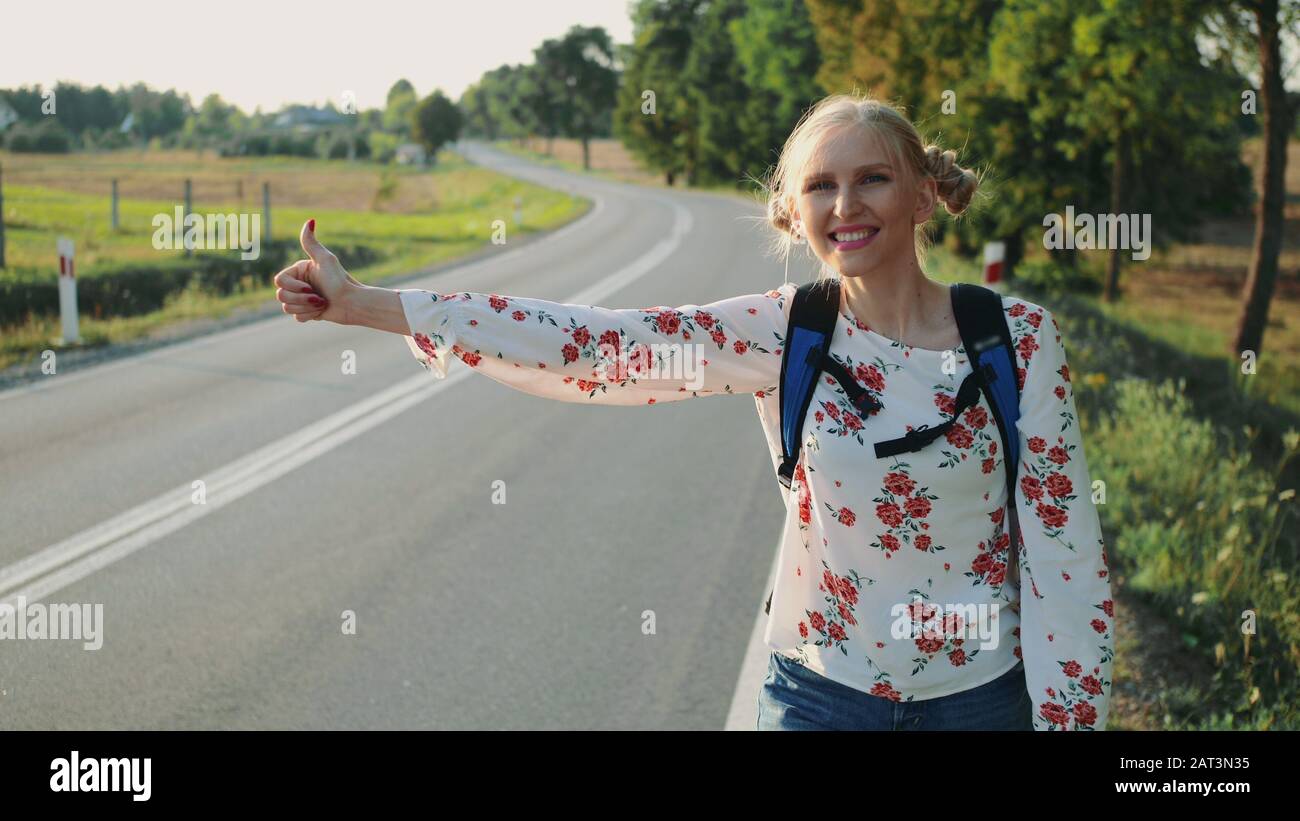 Wanderlust: Une jeune dame en voyage quitte la maison avec sac à dos. Randonneur Randonnée Seule Au Coucher Du Soleil Avant La Nuit, La Jeune Fille Sur La Route, Solo Femme Hitchhiker, Girls Trips. Banque D'Images