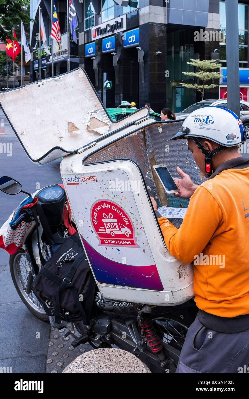 Man vérifie la livraison d'un paquet sur son téléphone mobile, Ho Chi Minh City, Vietnam Banque D'Images