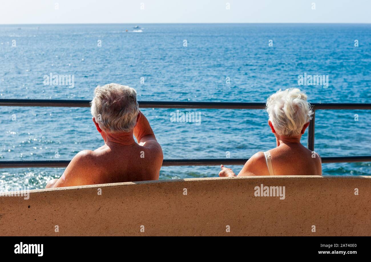 Île des Canaries TENERIFE, ESPAGNE - 27 DEC, 2019: Un couple à la retraite est assis sur un banc profitant du soleil et de la vue sur Tenerife. Banque D'Images