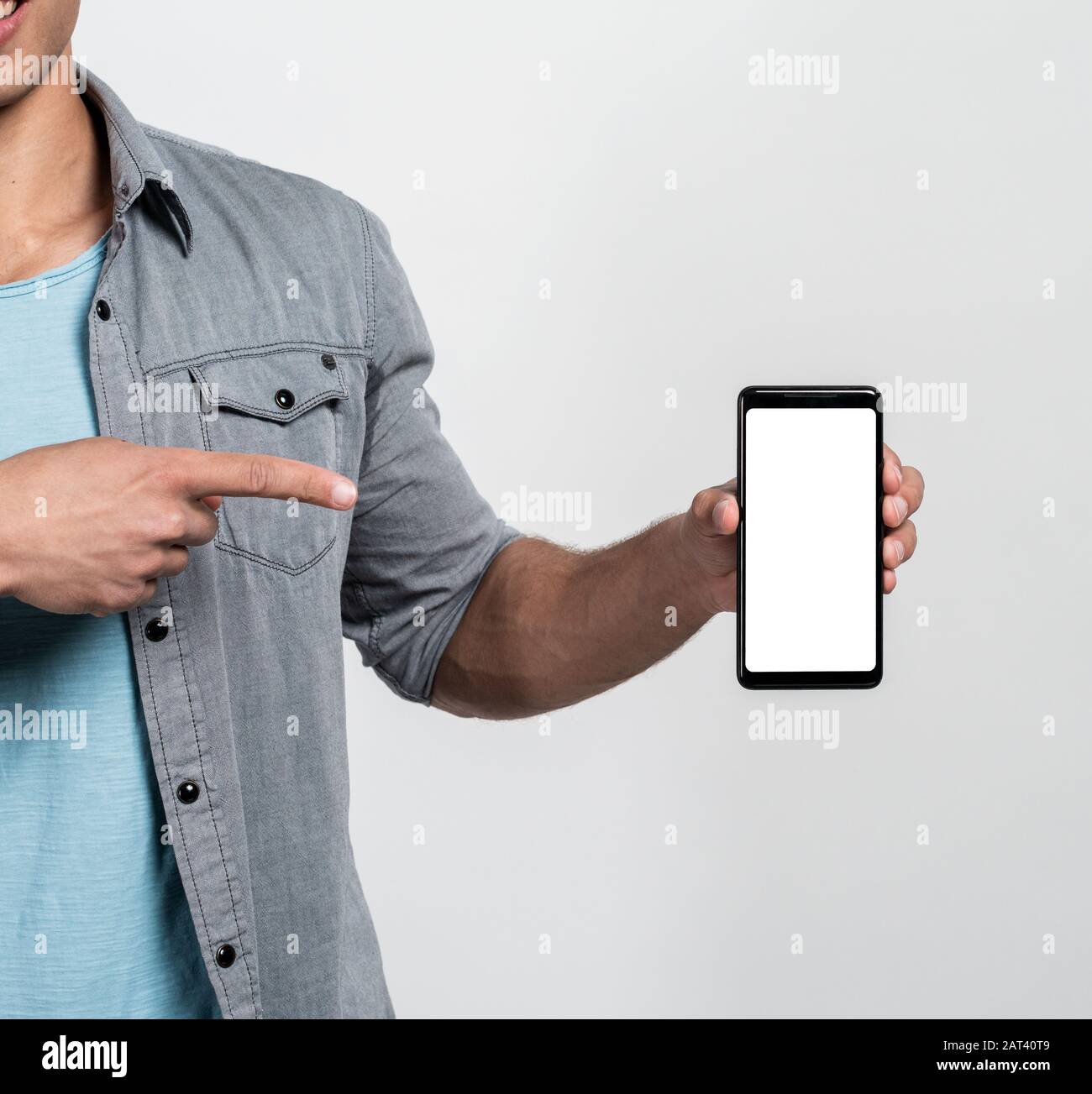 Maquette un smartphone avec écran blanc. Doigt mâle vers le téléphone Banque D'Images