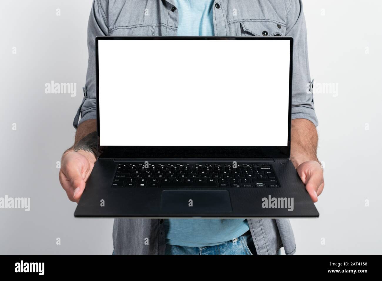 Gros plan un écran blanc de maquette d'ordinateur portable dans les mains des hommes. - image de concept Banque D'Images