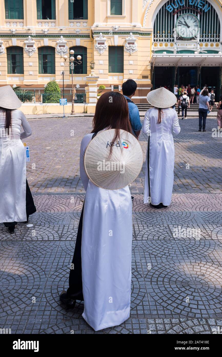 Les femmes portant la robe Ao Dai à l'extérieur de la poste centrale, Ho Chi Minh Ville, Vietnam Banque D'Images