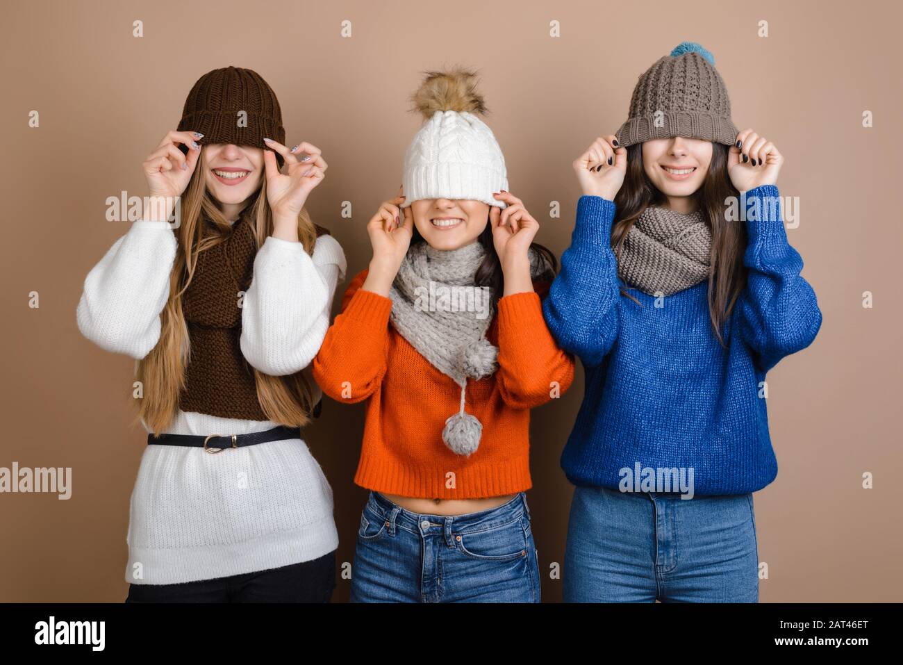 Les filles drôles dans les foulards ont tiré leur chapeau sur leurs yeux Banque D'Images