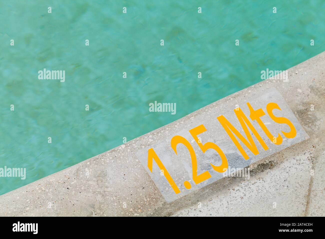 1,25 mètre de profondeur, texte d'avertissement jaune sur un bord de piscine Banque D'Images