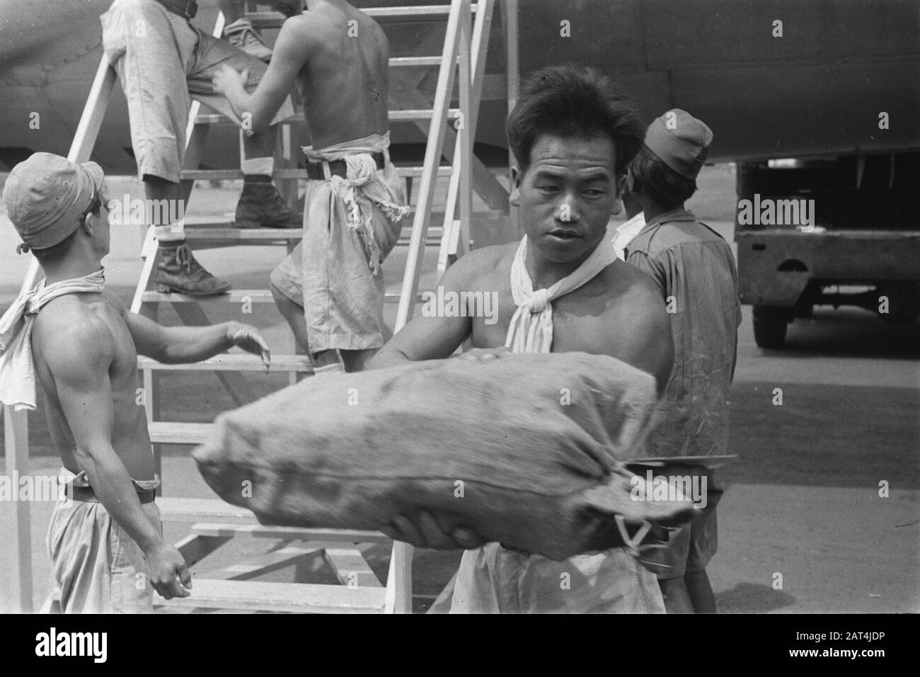 Arrivée de colis avec des avions KLM prisonniers de guerre japonais sortir les sacs de l'avion Date: Décembre 1946 lieu: Indonésie, Antilles néerlandaises de l'est Banque D'Images