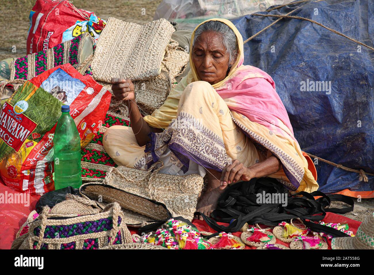 Femme rurale à coudre des articles artisanaux en jute pour la vente à un tarif artisanal à Kolkata Banque D'Images