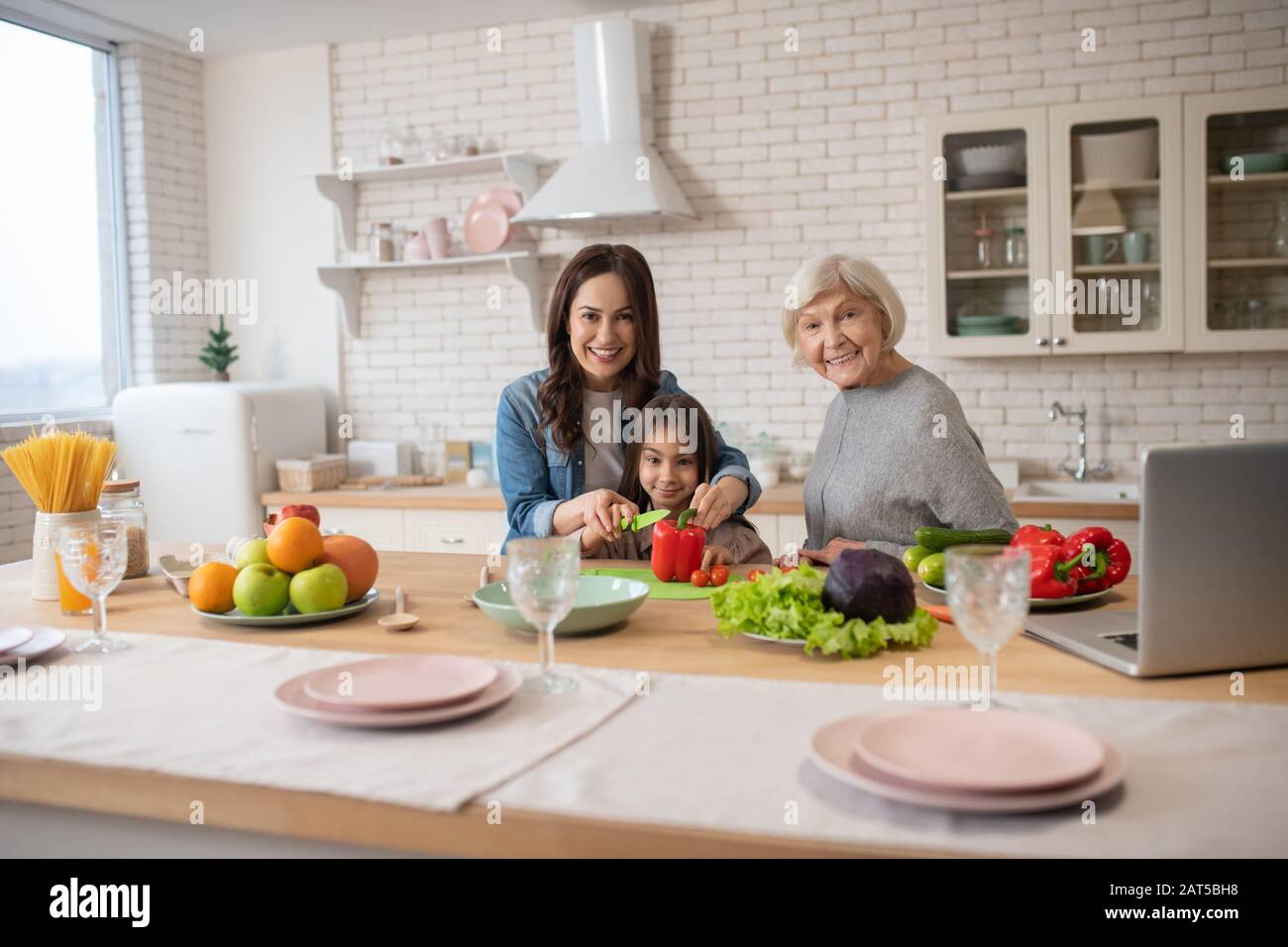 Rire la mère grand-mère et la fille ensemble près de la table de cuisine. Banque D'Images