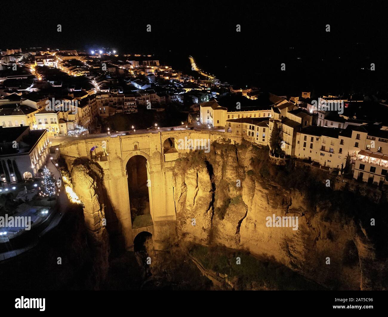 Photo aérienne drone point de vue énorme gorge et architecture ancienne, ville lumière la nuit vue de Ronda dans la province espagnole de Málaga. Espagne Banque D'Images