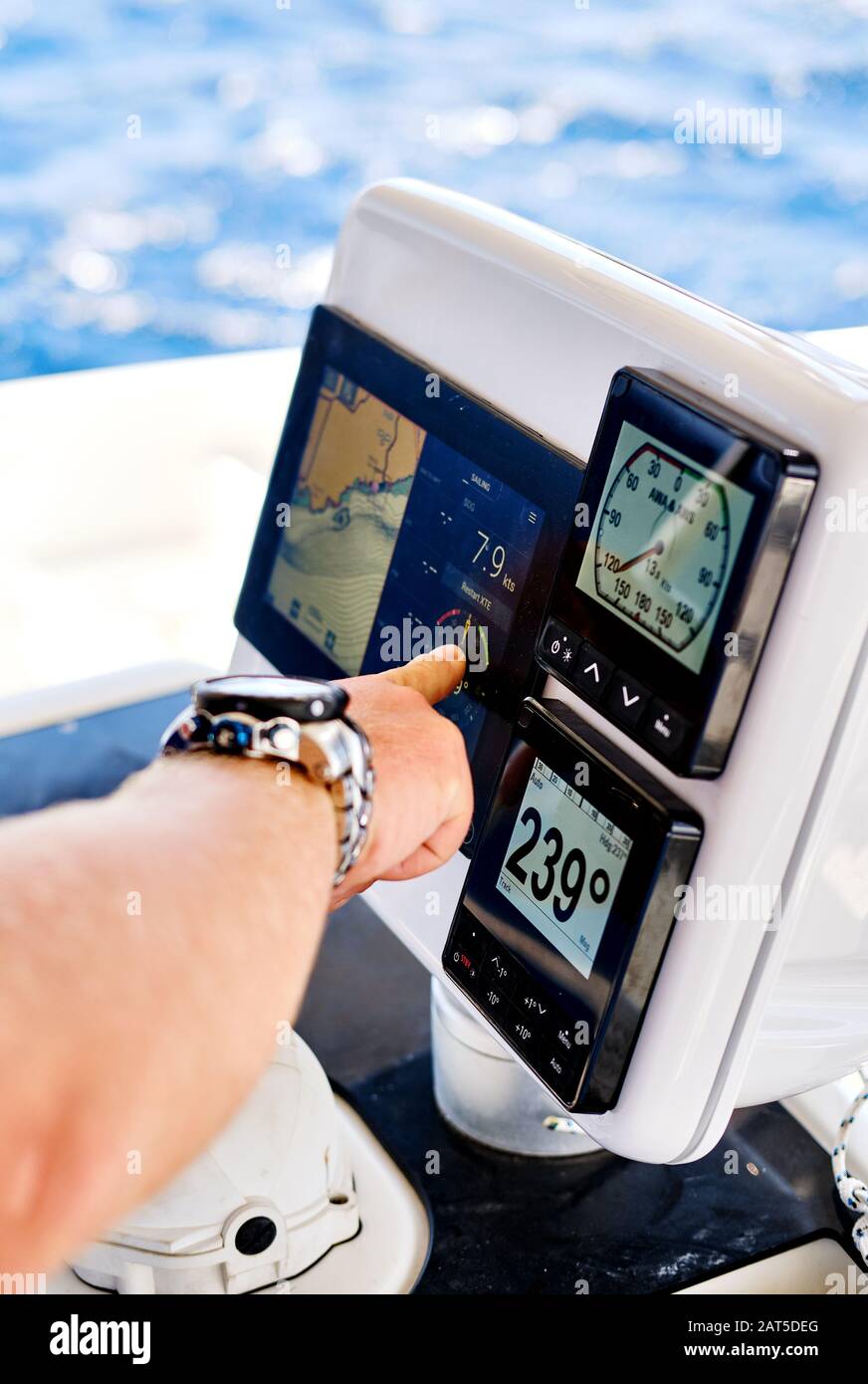 Gros plan main masculine pointant sur les dispositifs de navigation dans la terrasse en catamaran, sport de loisirs d'aventure, concept de yachting Banque D'Images