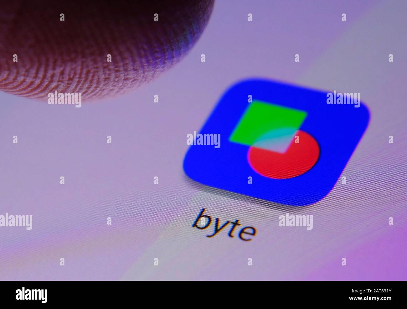 Icône de l'application BYTE sur l'écran tactile et doigt au-dessus. BYTE est une nouvelle plate-forme vidéo de réseaux sociaux. Banque D'Images