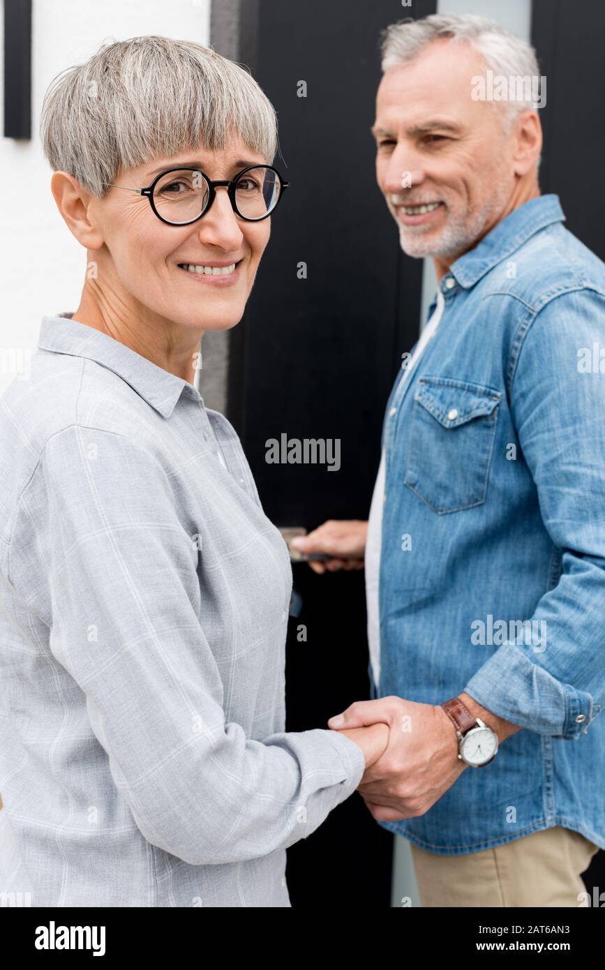 homme mûr regardant une femme souriante et entrant dans une nouvelle maison Banque D'Images