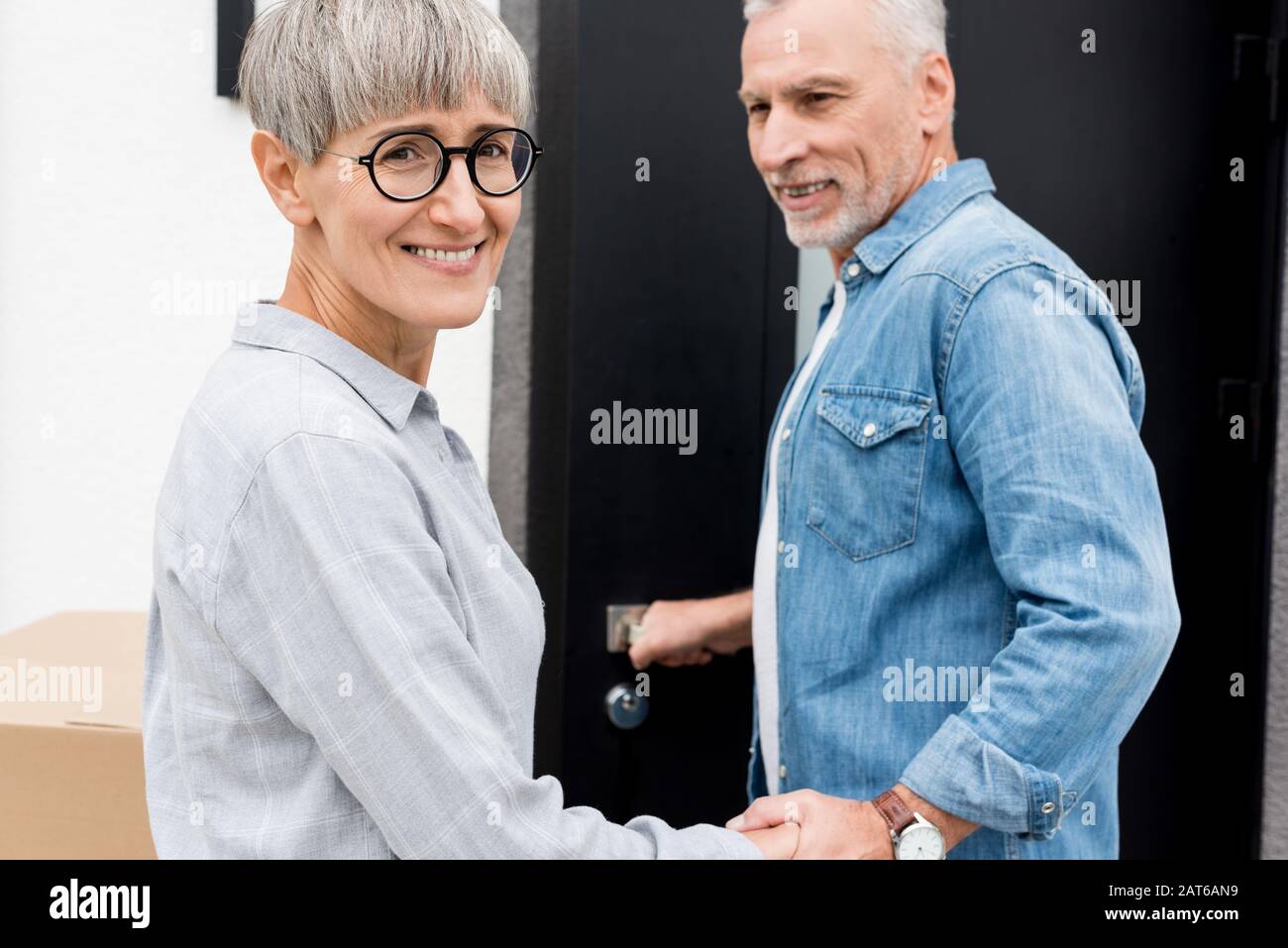 homme mûr regardant une femme souriante et entrant dans une nouvelle maison Banque D'Images