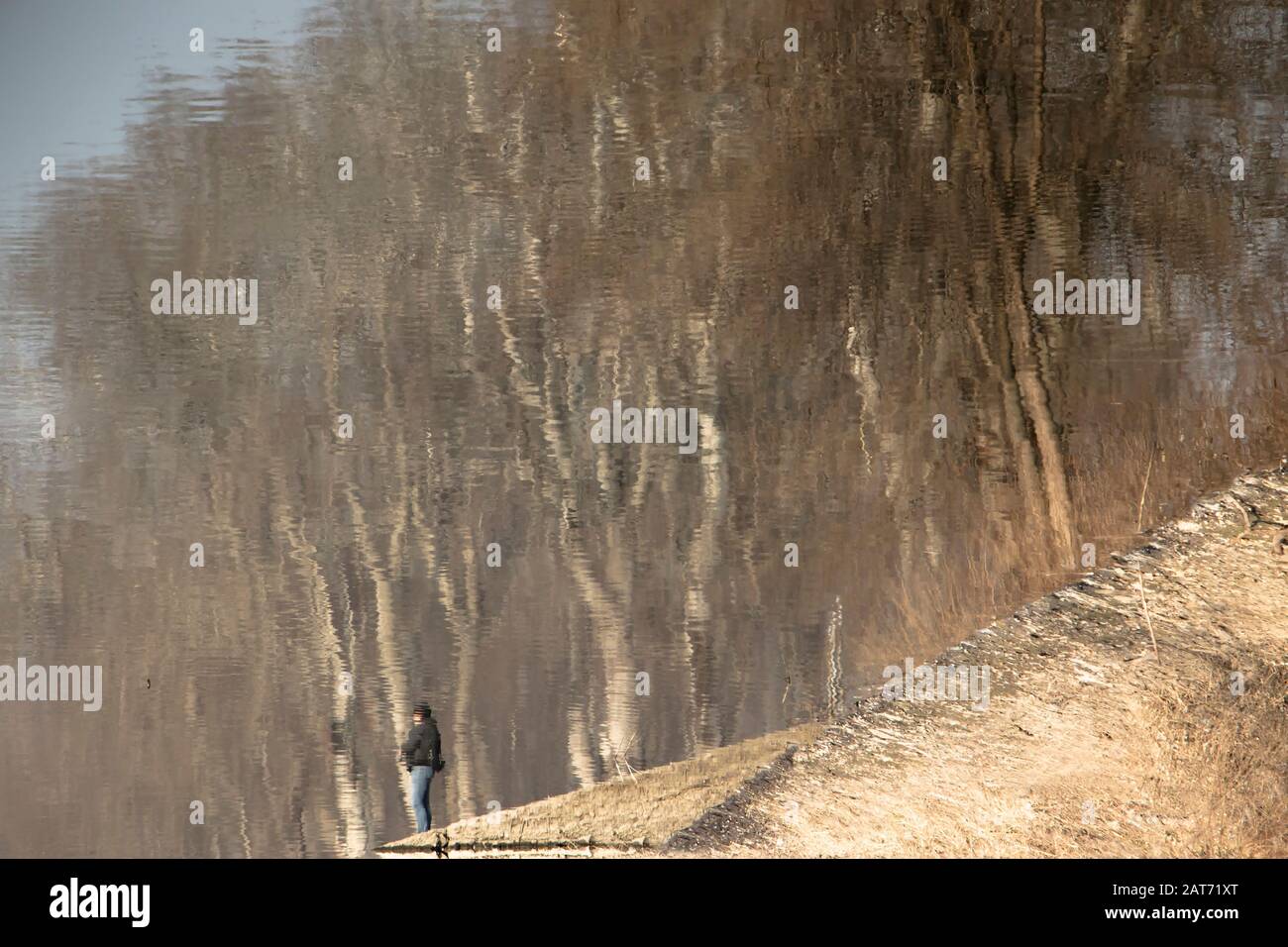 Silhouette floue reflet d'une personne et d'une forêt dans les eaux de la rivière, un jour ensoleillé Banque D'Images