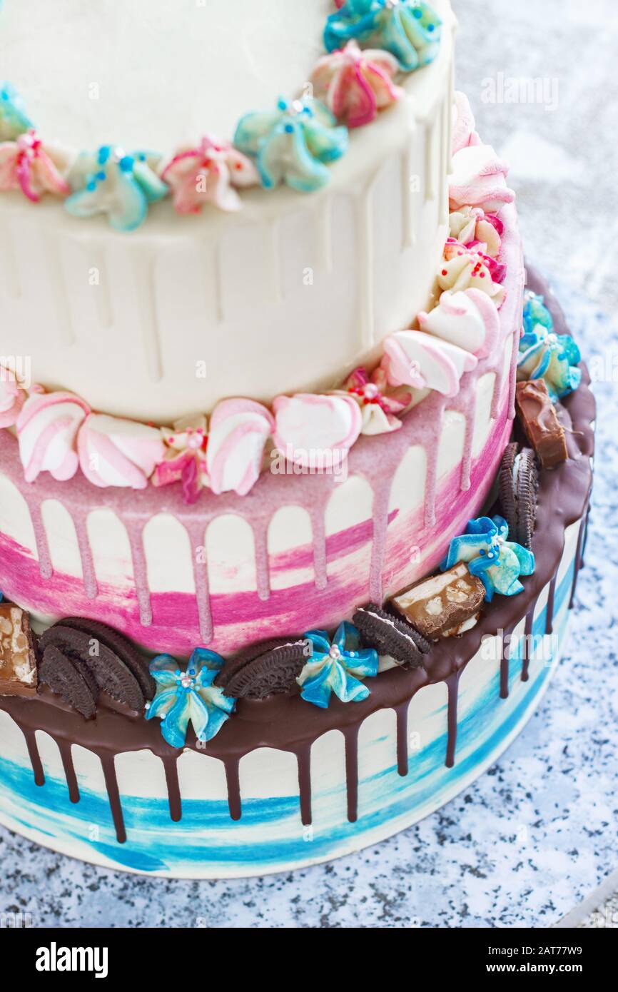 Gâteau de couleur à trois niveaux avec des taches de chocolat colorées sur un fond clair. Photo pour un menu ou un catalogue de confiseries, le gâteau de mariage Banque D'Images