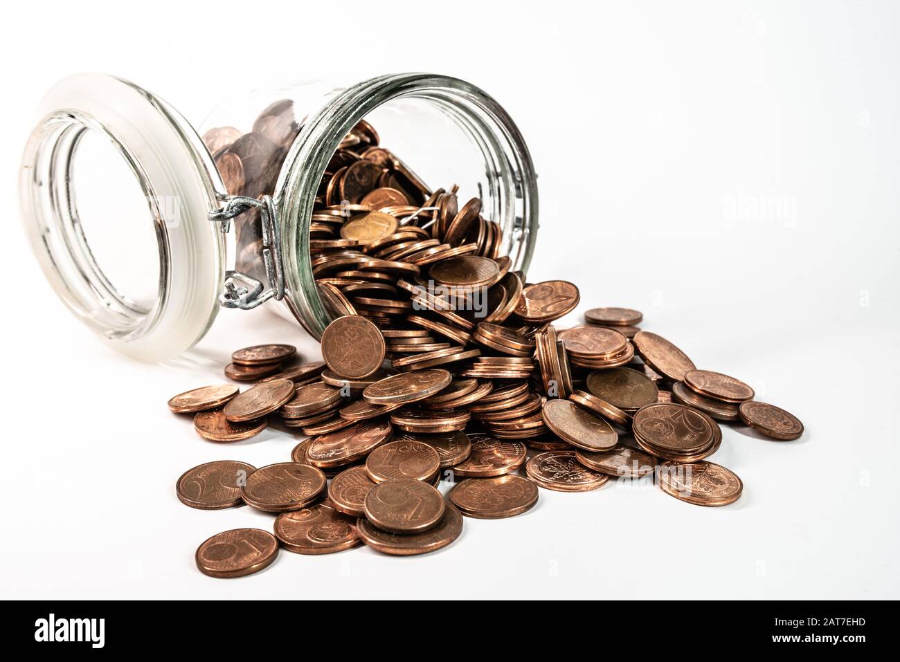 petites pièces de monnaie en euros de changement coulant hors du pot en verre isolé sur fond blanc, retrait du concept de pièces de monnaie de faible valeur nominale Banque D'Images