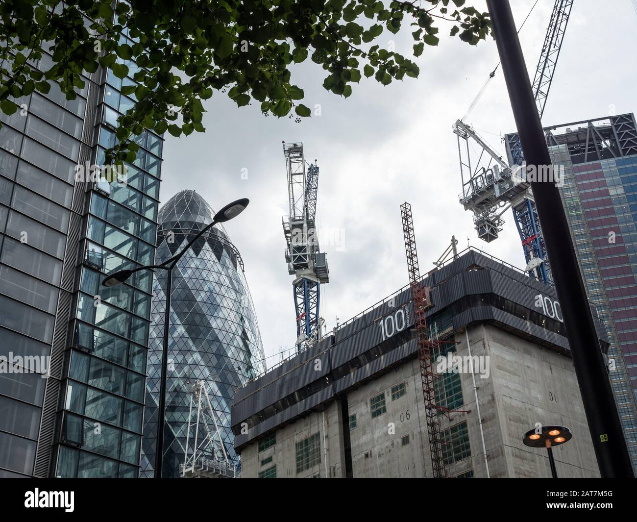 Travaux de construction de la ville de Londres entourés de gratte-ciel établis, dont les bâtiments Gherkin, Heron et Leadenhall. Banque D'Images
