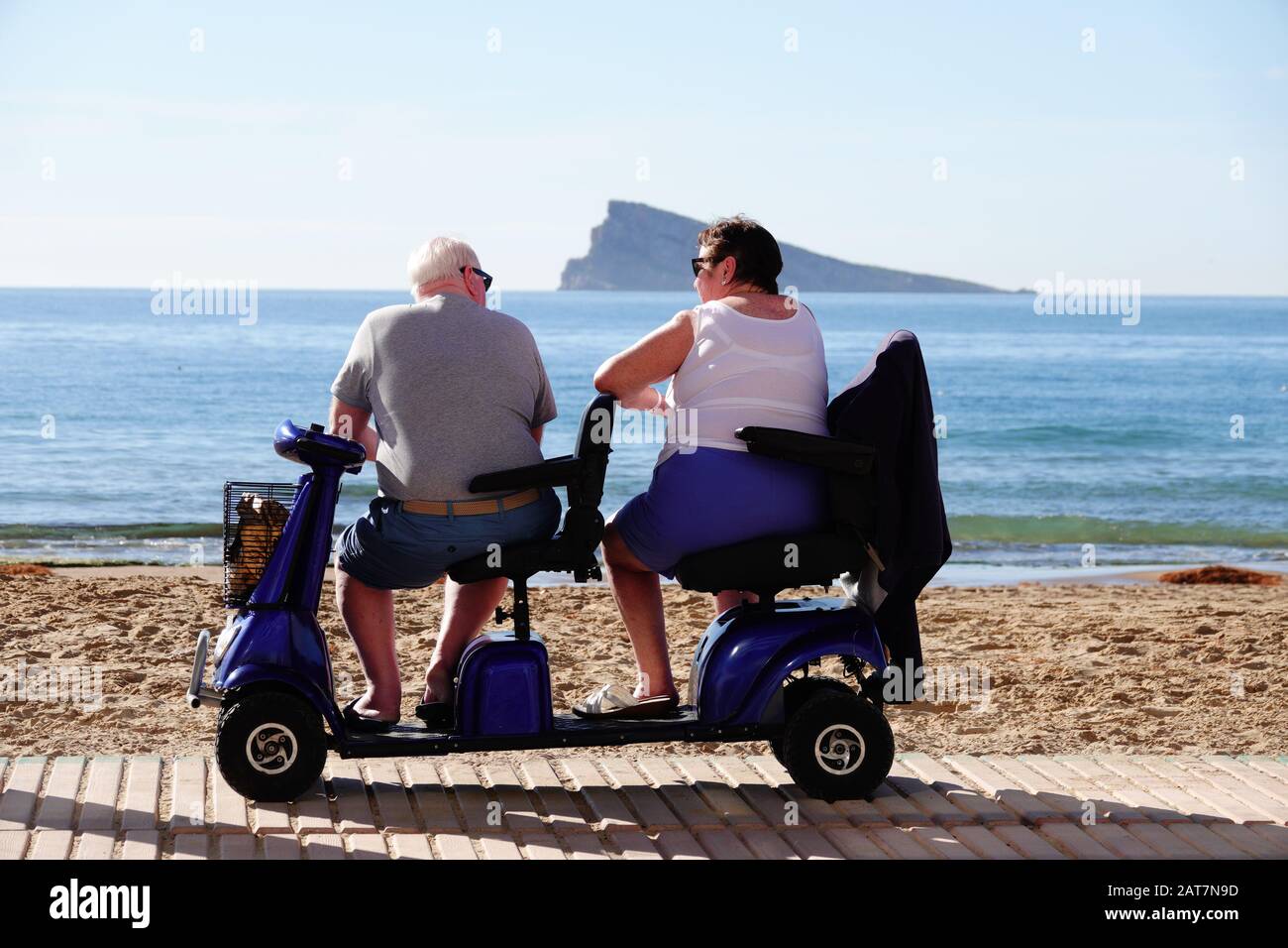 Benidorm, province d'Alicante, Espagne. 31 janvier 2020. Les touristes  britanniques OAP se détendent au soleil sur la plage de Levante sur un  scooter à double mobilité Photo Stock - Alamy