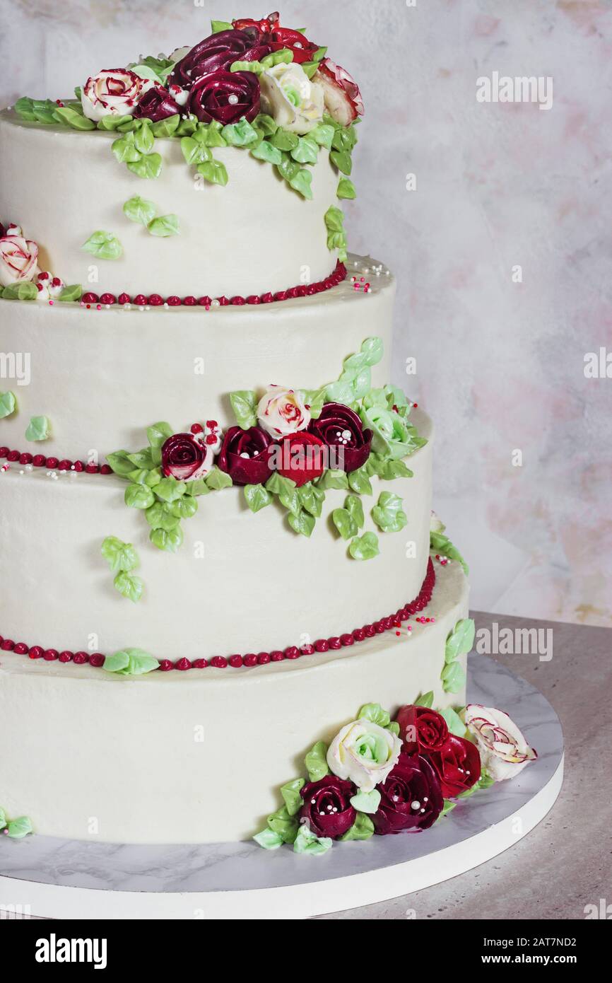 Gâteau élégant blanc de quatre niveaux festif avec fleurs de crème, gâteau de mariage, fleurs de crème dans la technique malaisienne Banque D'Images