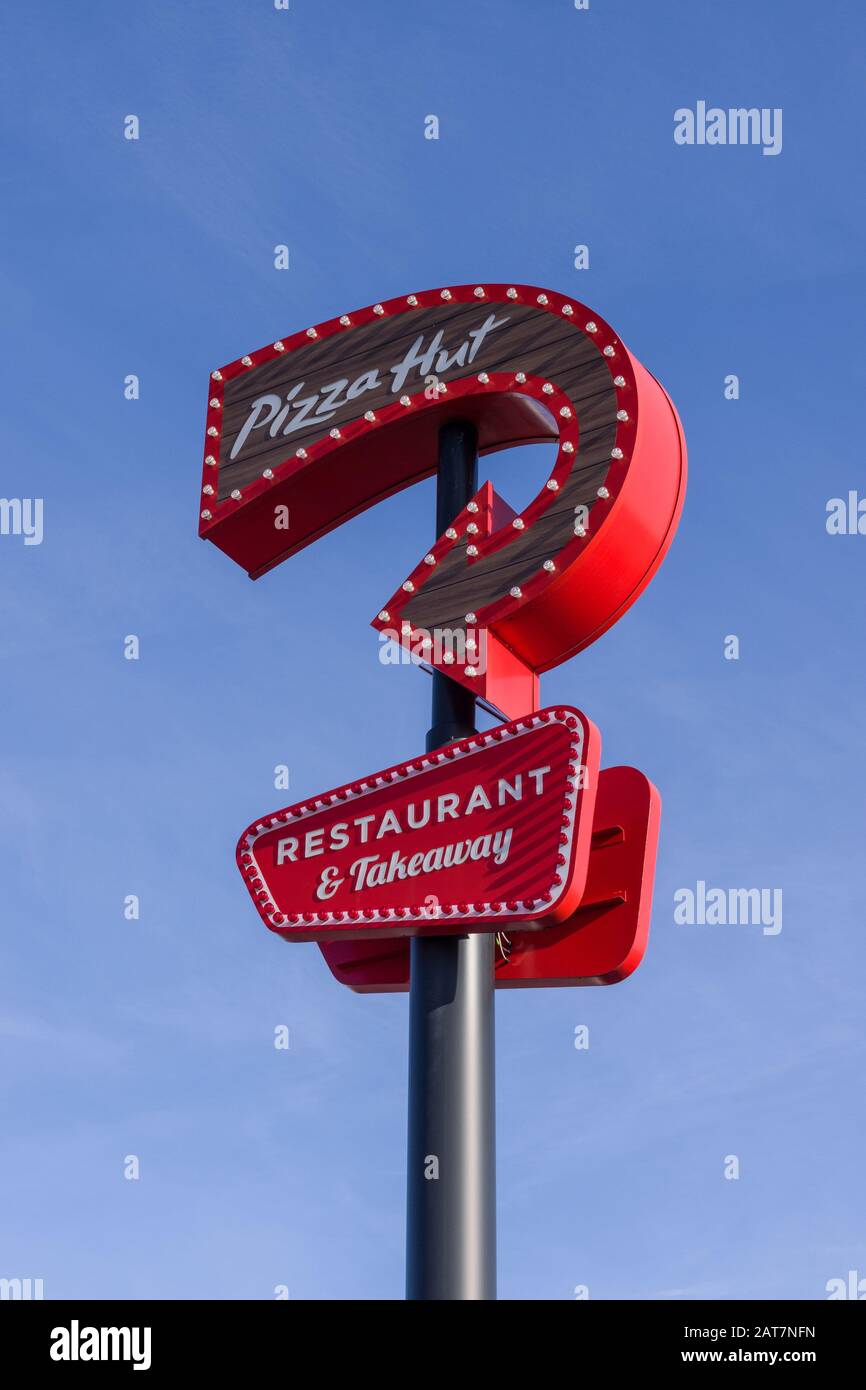 Panneau rouge pour Pizza Hut contre un ciel bleu; restaurant et à emporter, Sixfields, Northampton, Royaume-Uni Banque D'Images