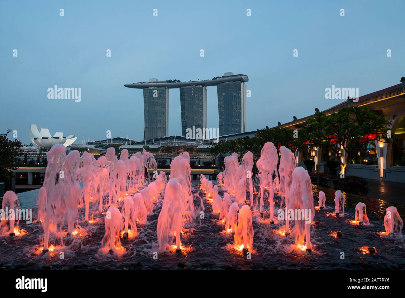 Singapour. Janvier 2020. Les fontaines colorées de Marina Bay avec les Sables de Marina Bay au coucher du soleil en arrière-plan Banque D'Images