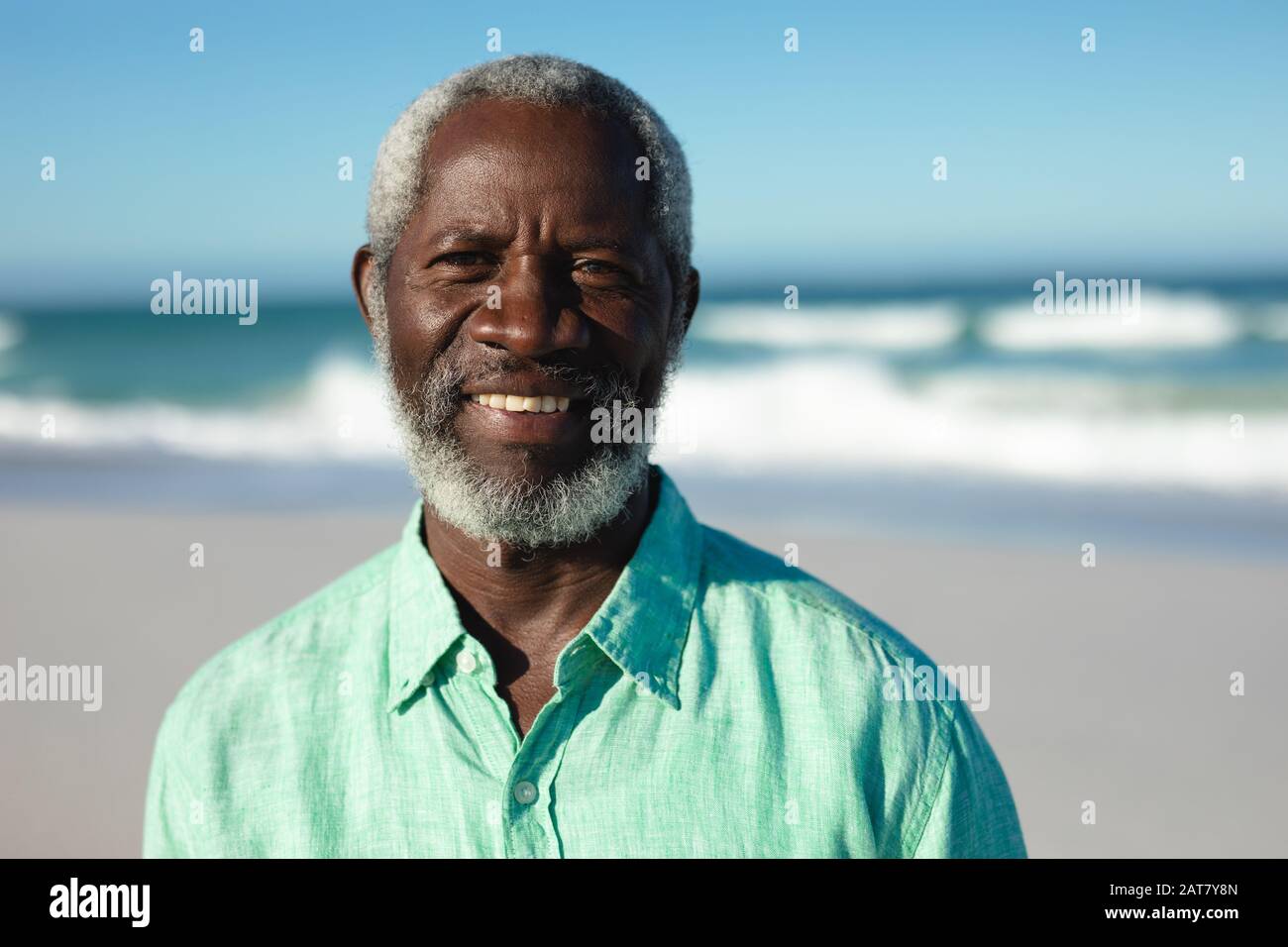 Vieil homme souriant à la plage Banque D'Images