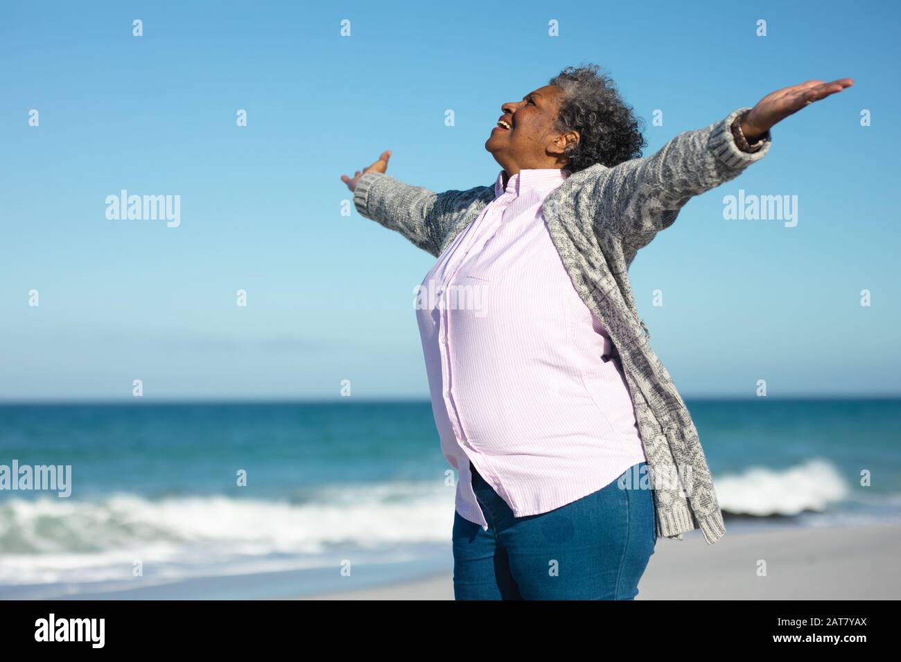 Vieille femme souriante à la plage Banque D'Images