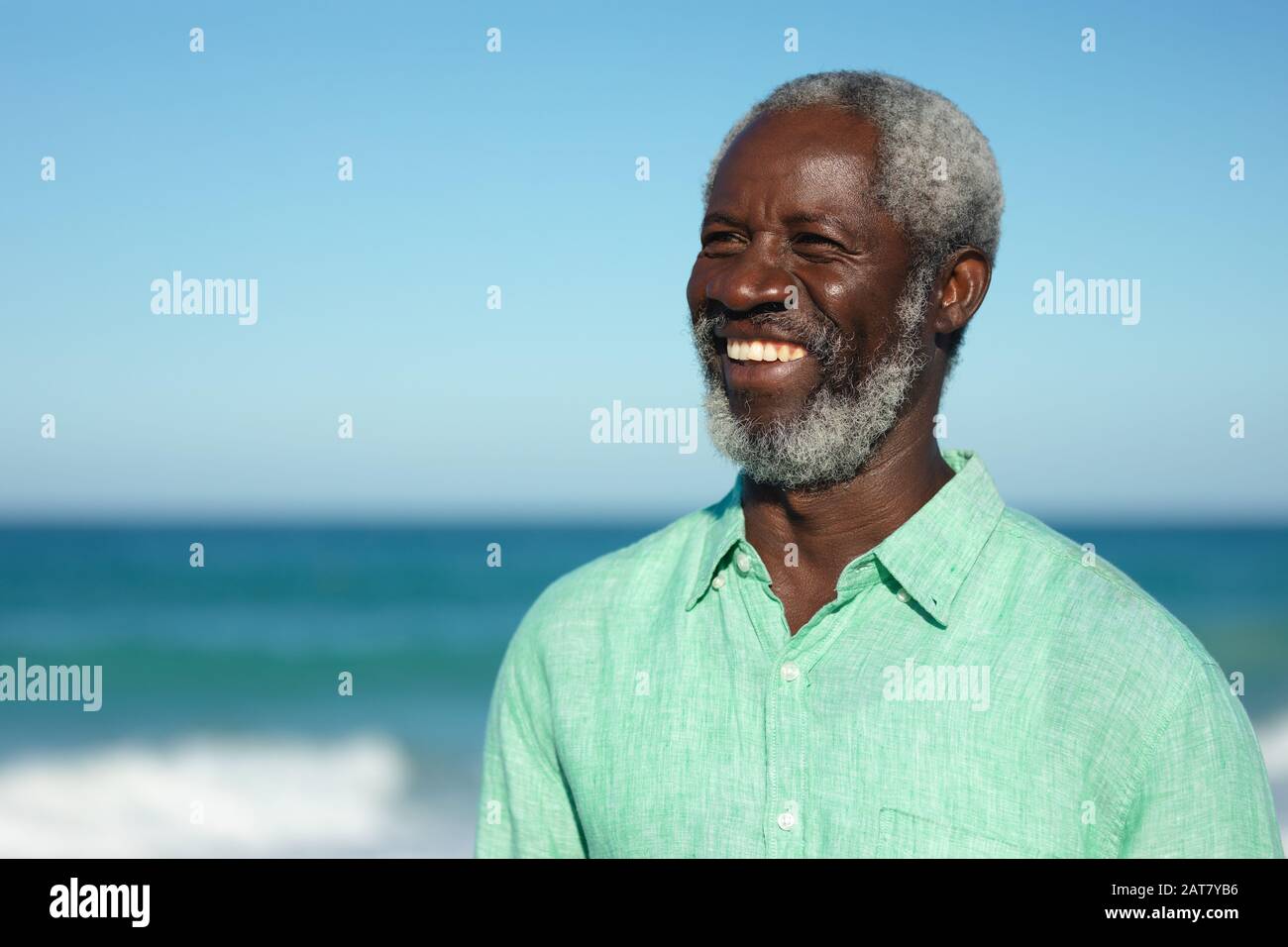 Vieil homme souriant à la plage Banque D'Images