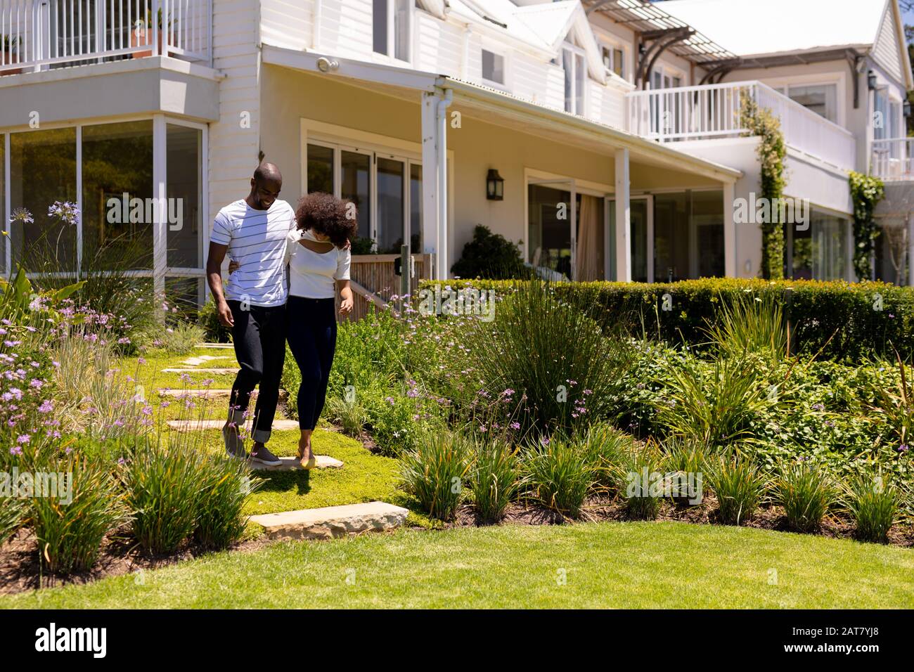 Jeune couple marchant dans le jardin Banque D'Images