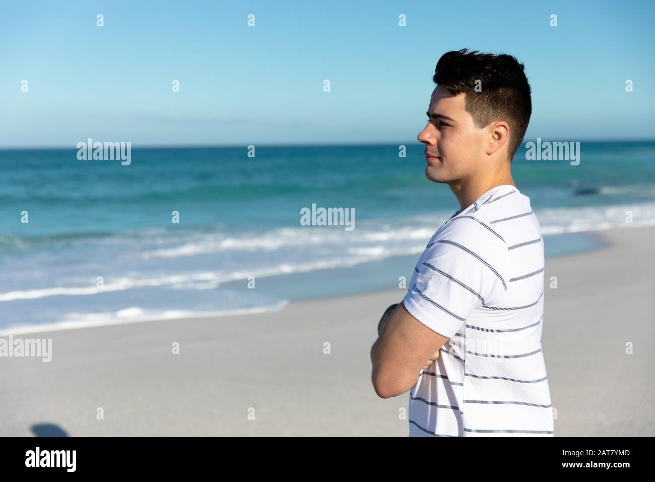 Vue latérale sur le jeune homme à la plage Banque D'Images