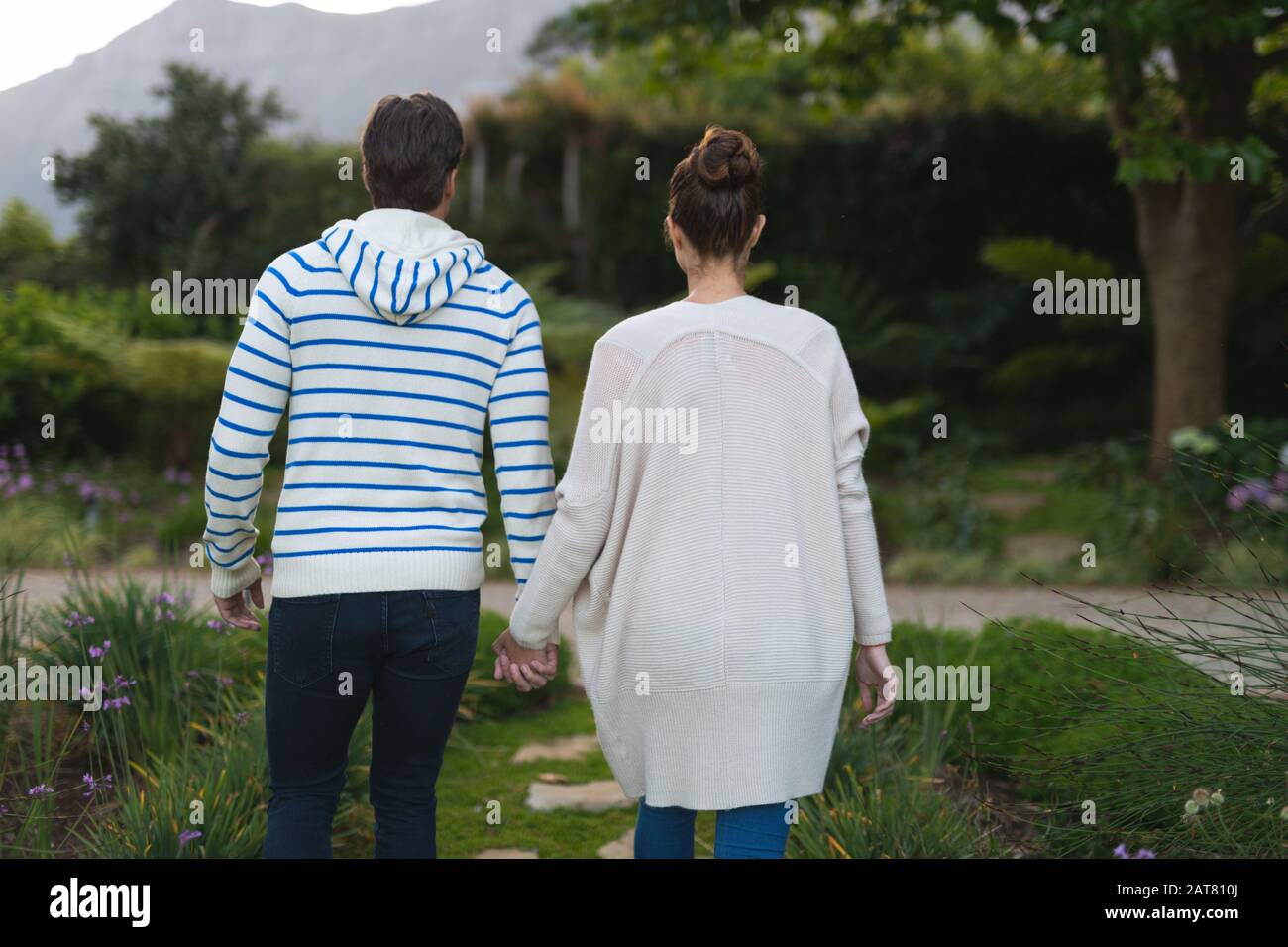 Jeune couple tenant les mains dans le jardin Banque D'Images