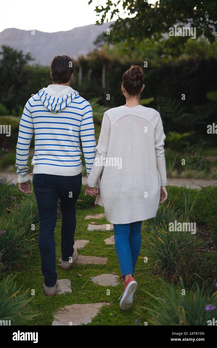 Jeune couple tenant les mains dans le jardin Banque D'Images