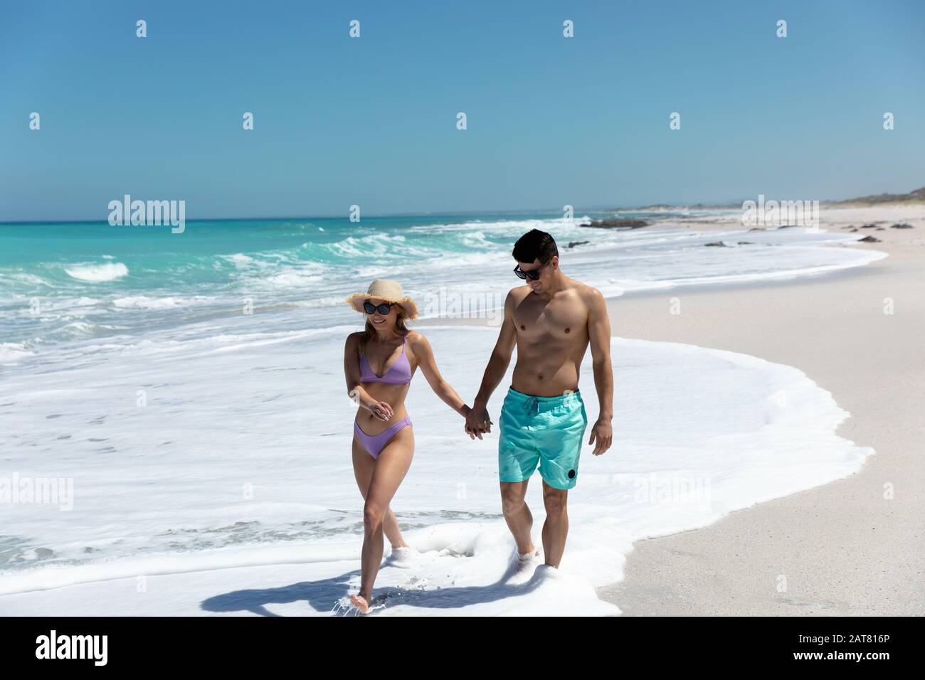Un jeune couple marchant à côté de la plage Banque D'Images