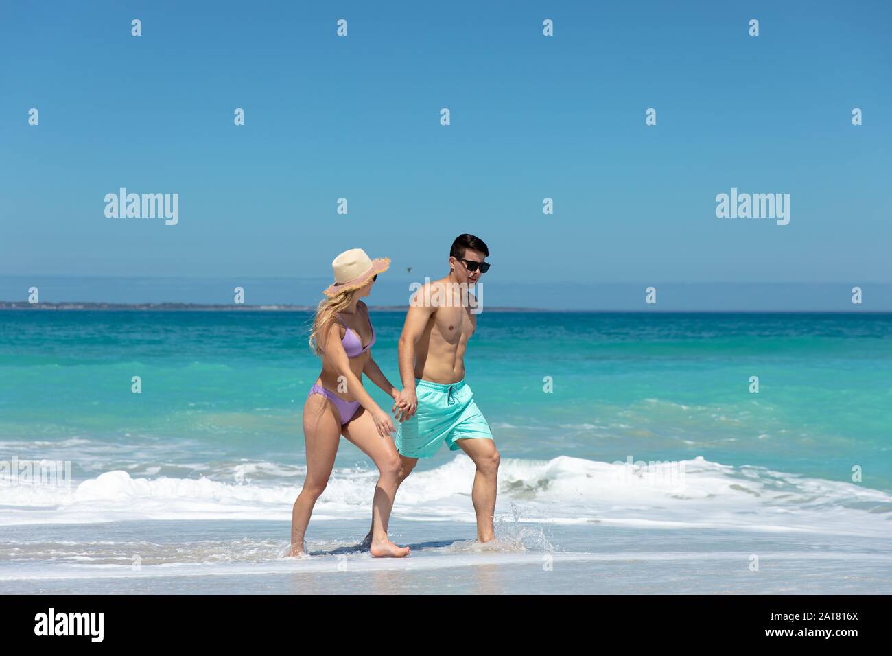 Un jeune couple marchant à côté de la plage Banque D'Images