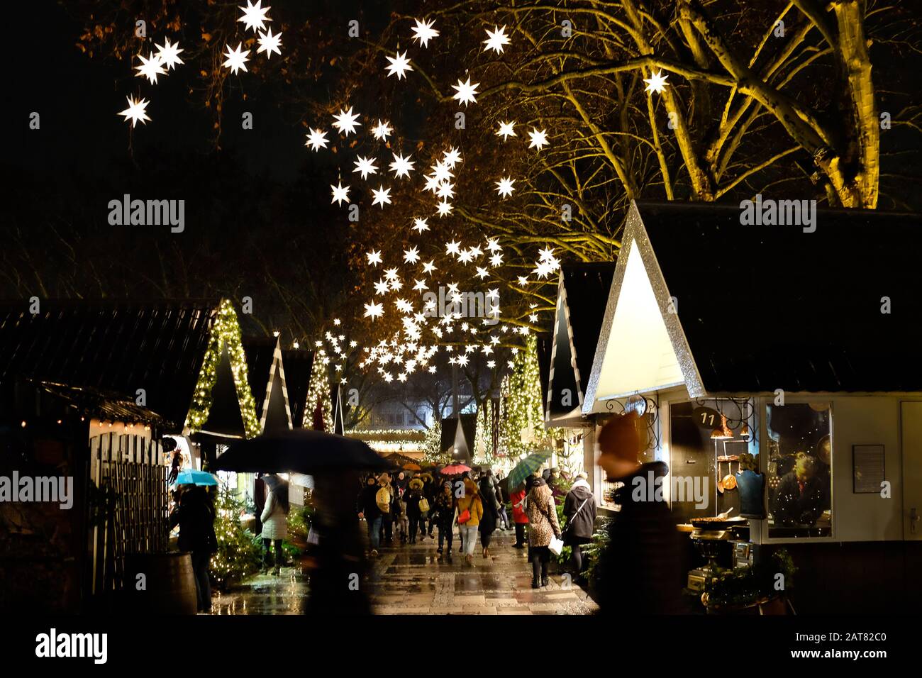 Marché allemand de Noël la nuit avec des étals de marché et des étoiles illuminées Banque D'Images