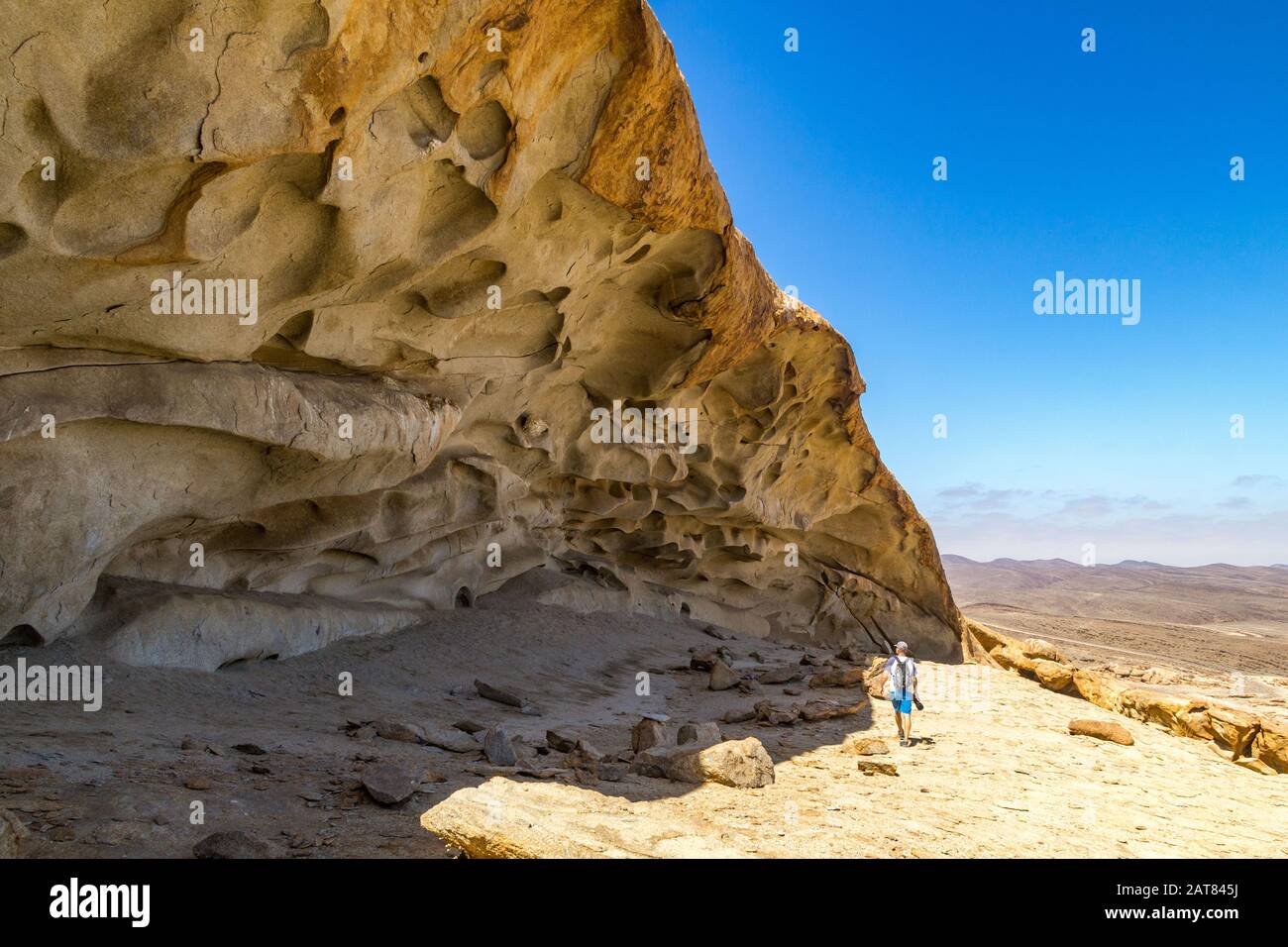 Homme marchant regardant quelques bizarres formations rocheuses à Blutkuppe au-dessus du désert du parc Namib Naukluft, Namibie, Afrique Banque D'Images