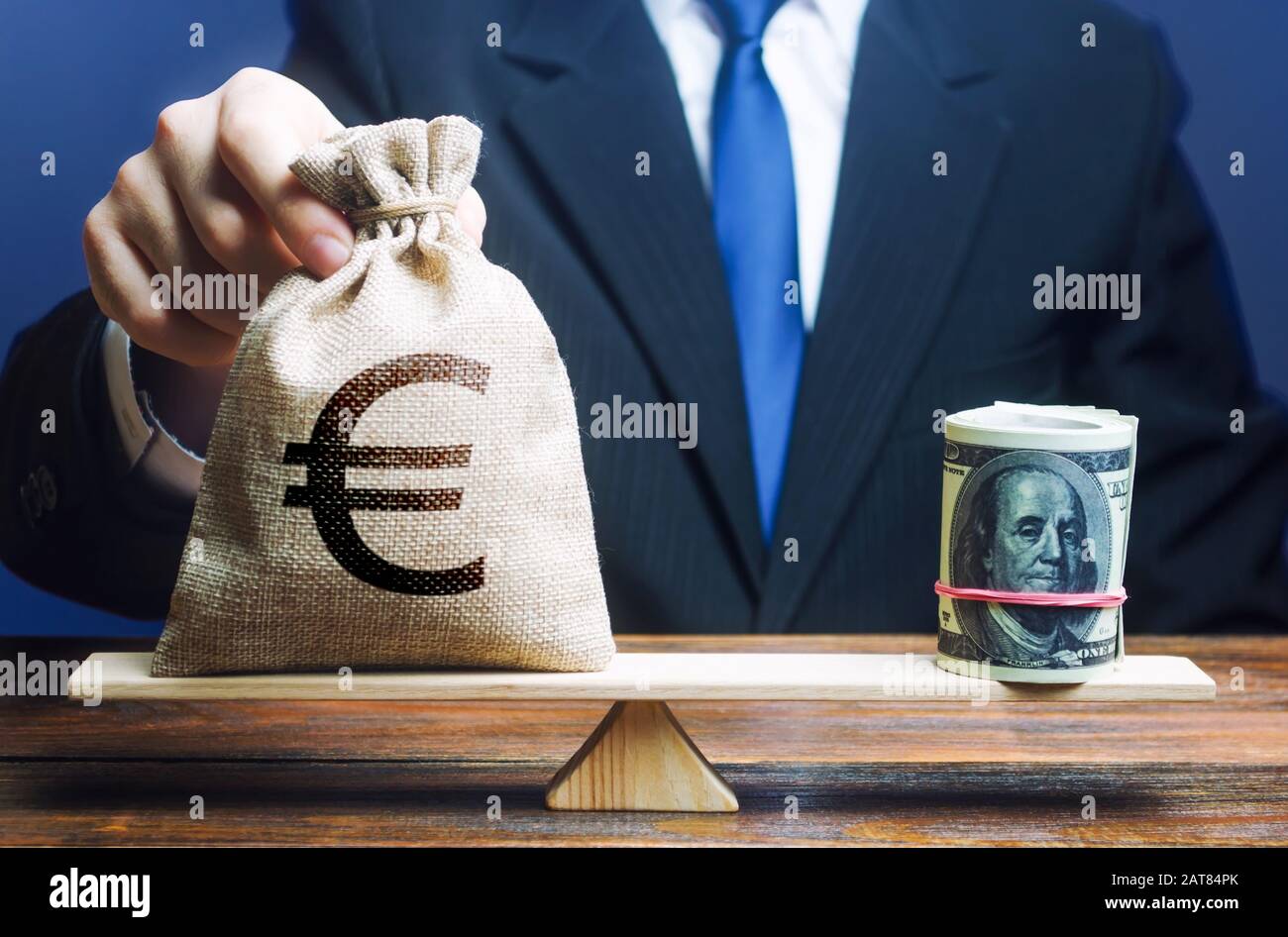 Man met un sac d'argent en euros sur des échelles en face de l'offre groupée en dollars. Taux de change, indicateurs économiques de comparaison. Éviter l'inflation de l'épargne. Pol. Monétaire Banque D'Images